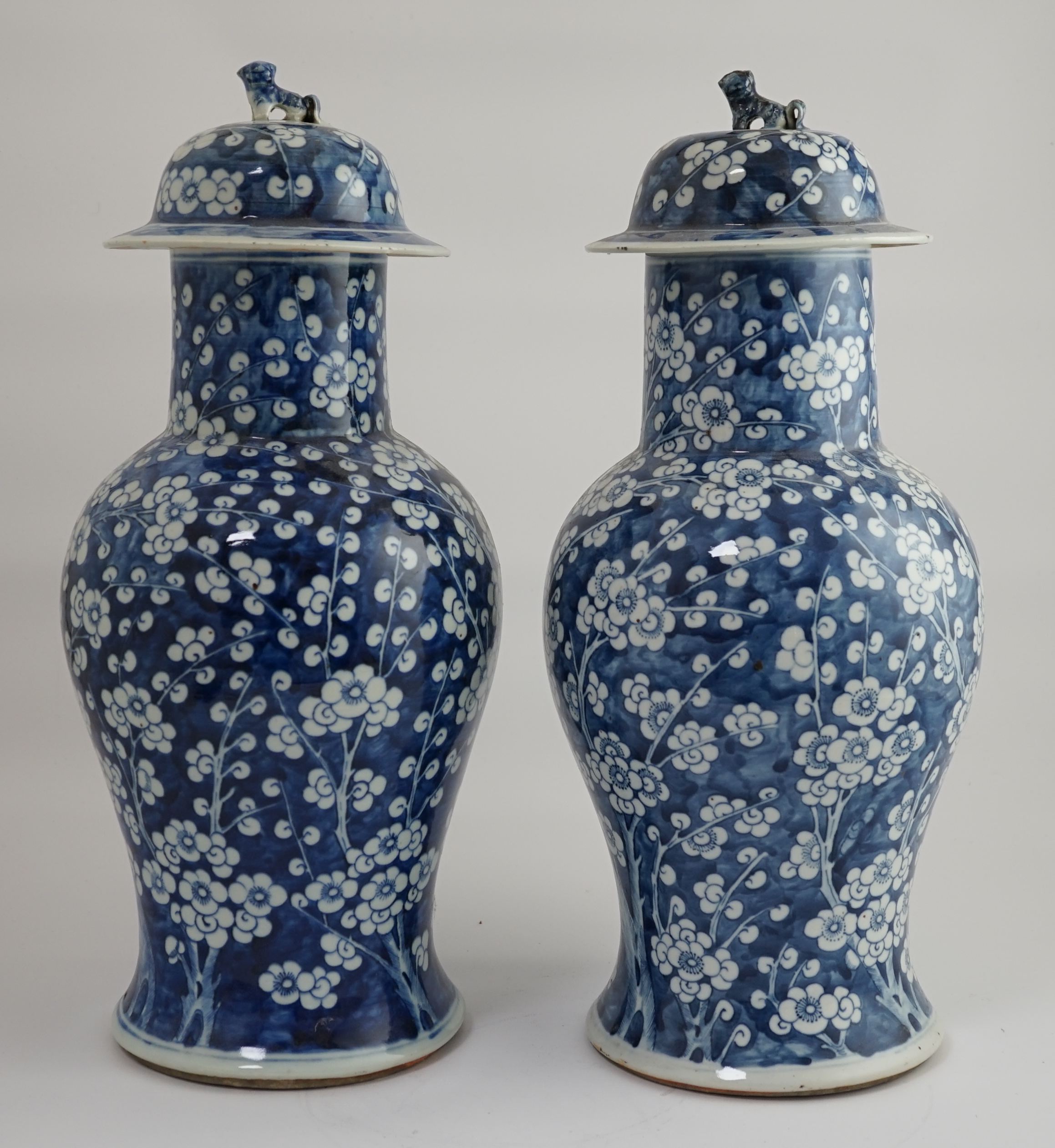 A pair of large Chinese blue and white ‘prunus’ baluster vases and covers, 19th century